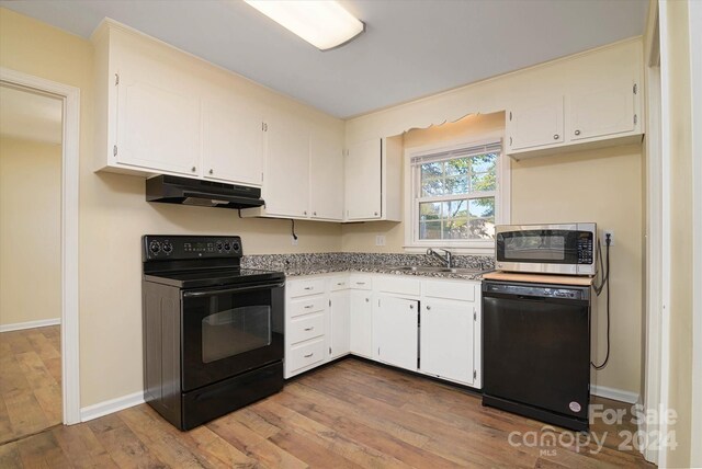 kitchen with black appliances, white cabinetry, and hardwood / wood-style flooring