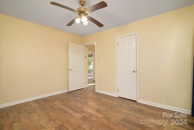 unfurnished bedroom with ceiling fan and wood-type flooring