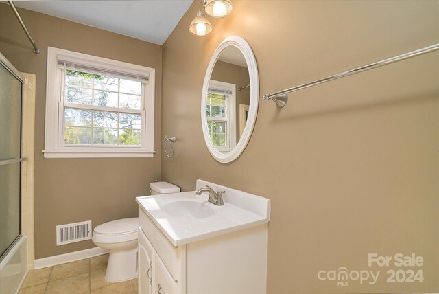 full bathroom featuring tile patterned flooring, toilet, vanity, and combined bath / shower with glass door