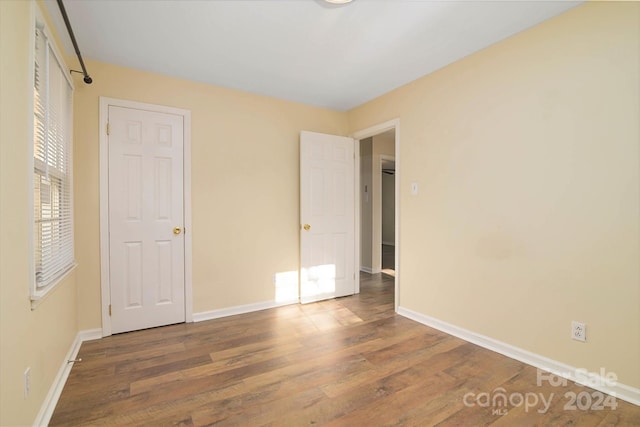 unfurnished bedroom with dark hardwood / wood-style flooring