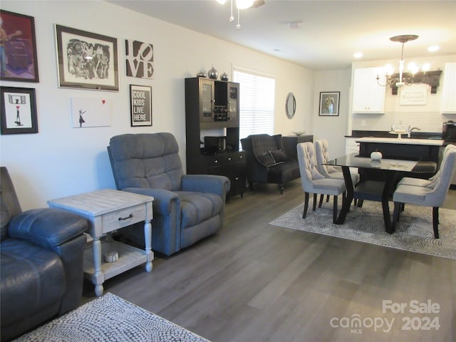 living room featuring dark wood-type flooring and a notable chandelier