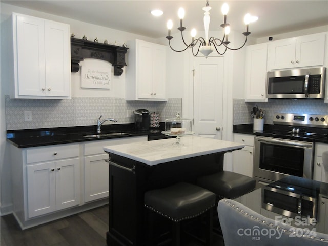 kitchen with tasteful backsplash, sink, dark hardwood / wood-style flooring, hanging light fixtures, and stainless steel appliances