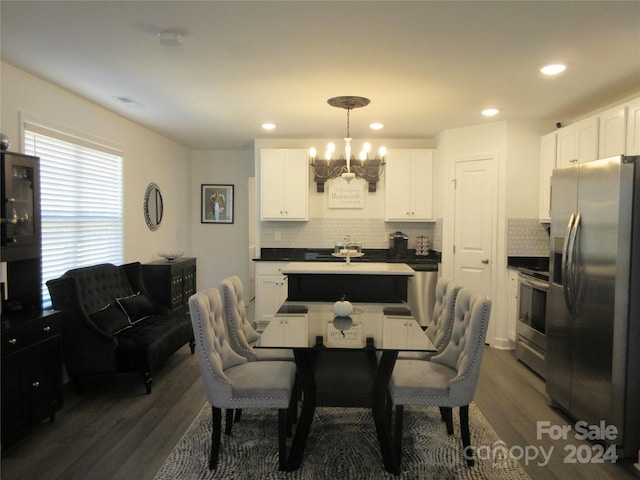 dining area featuring a chandelier, dark wood-type flooring, and sink