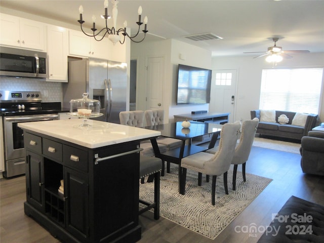 kitchen with white cabinetry, a healthy amount of sunlight, stainless steel appliances, and dark wood-type flooring