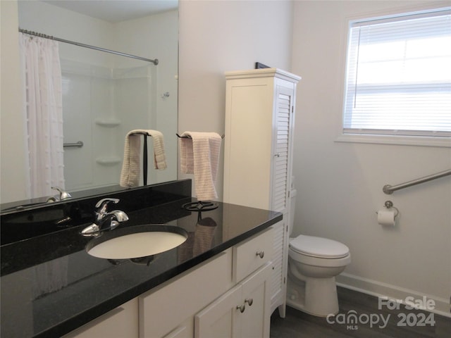 bathroom with vanity, toilet, a shower with shower curtain, and hardwood / wood-style floors