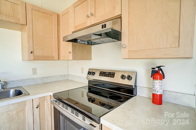 kitchen featuring sink, light brown cabinetry, and electric range