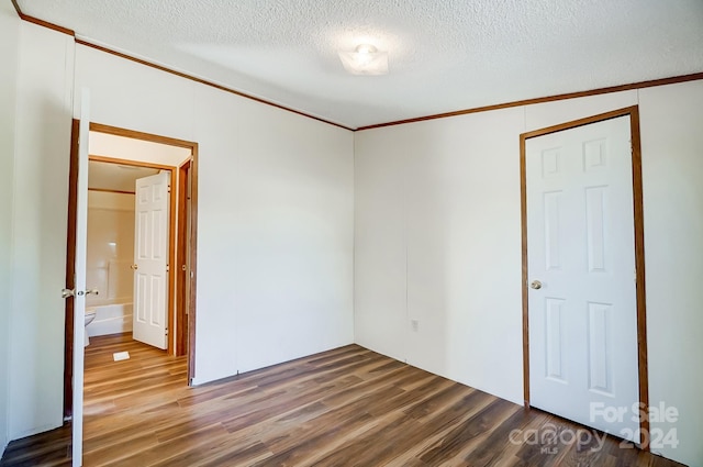 empty room featuring ornamental molding, a textured ceiling, and hardwood / wood-style flooring