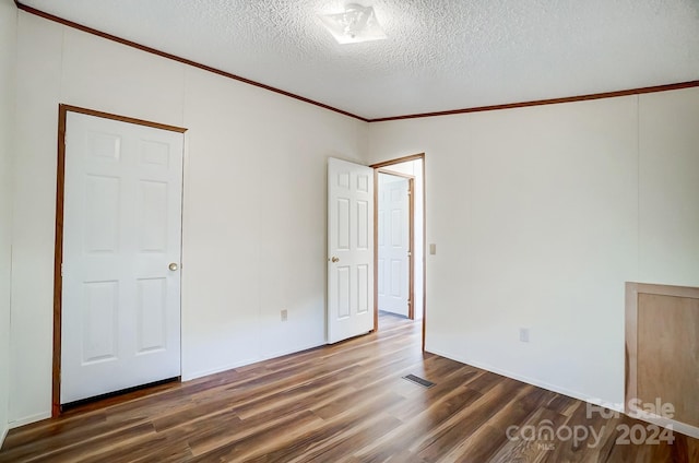 unfurnished room with crown molding, a textured ceiling, and dark hardwood / wood-style flooring