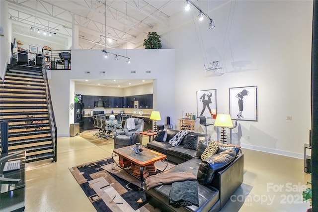 living room featuring track lighting and a high ceiling