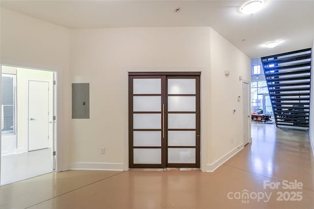 interior space with concrete flooring, floor to ceiling windows, and electric panel