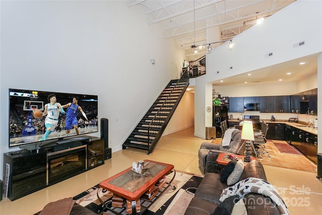 living room featuring a high ceiling, sink, and track lighting