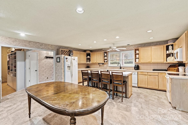 dining room with a textured ceiling, ceiling fan, and sink