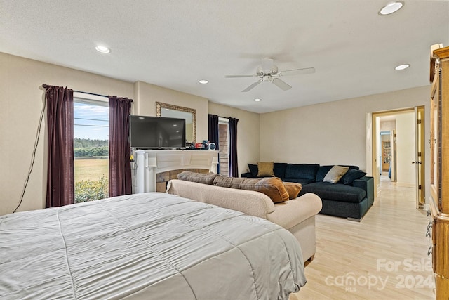 bedroom featuring ceiling fan, a textured ceiling, and light hardwood / wood-style flooring