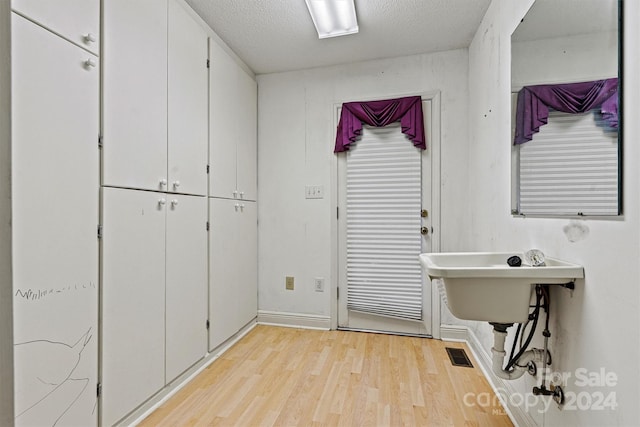 washroom featuring a textured ceiling and light wood-type flooring