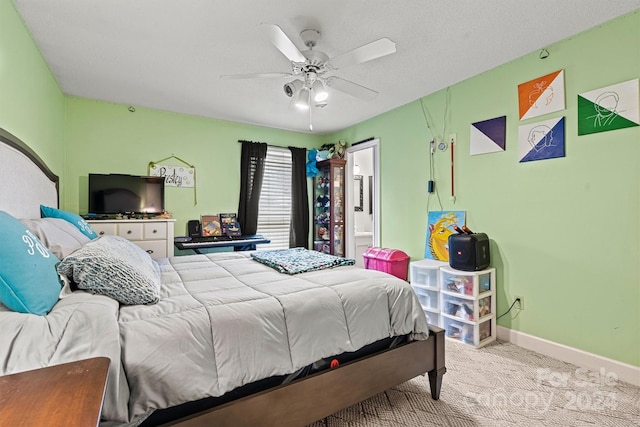 bedroom featuring a textured ceiling, light colored carpet, ceiling fan, and ensuite bathroom