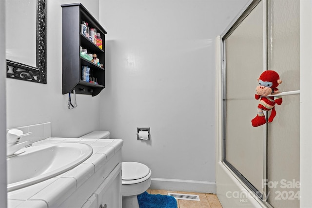 full bathroom featuring tile patterned flooring, enclosed tub / shower combo, toilet, and vanity