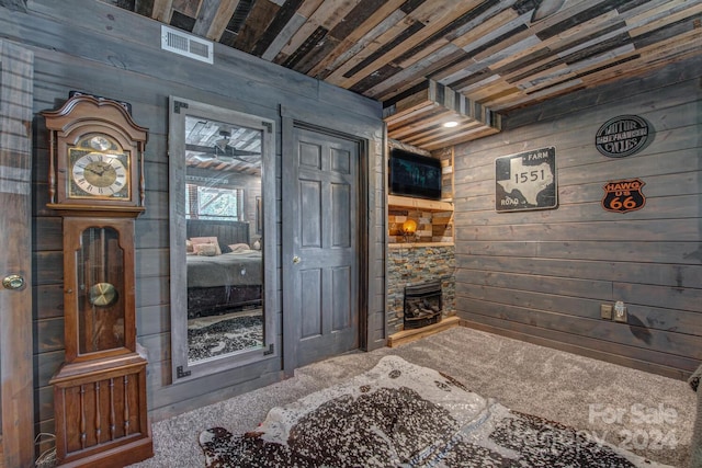 interior space with wood ceiling, carpet floors, and wood walls