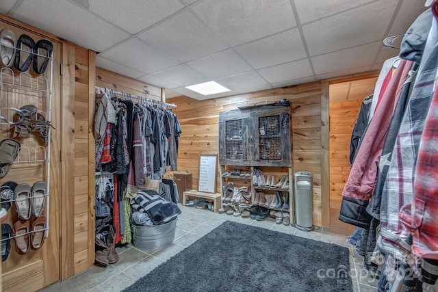 walk in closet with a drop ceiling and tile patterned flooring