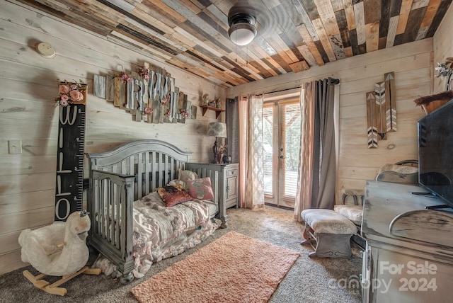 bedroom featuring wooden walls and access to outside