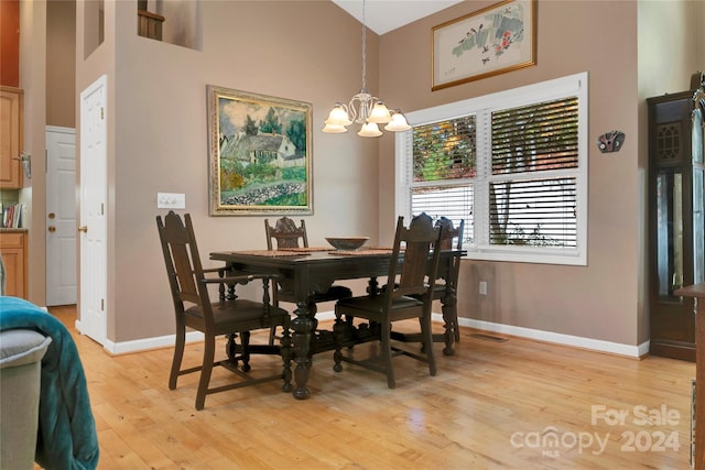 dining space featuring an inviting chandelier, high vaulted ceiling, and light wood-type flooring