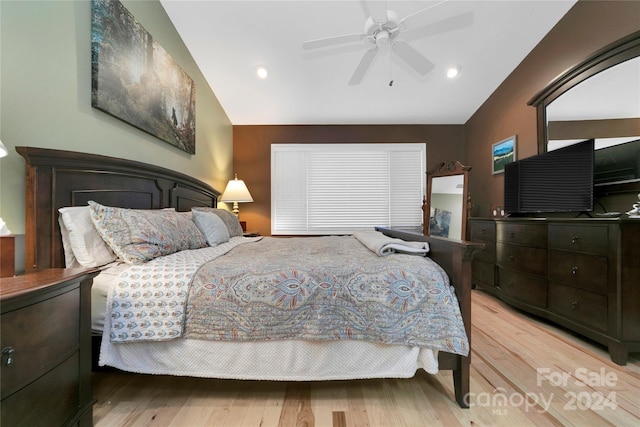 bedroom with ceiling fan, vaulted ceiling, and light hardwood / wood-style flooring