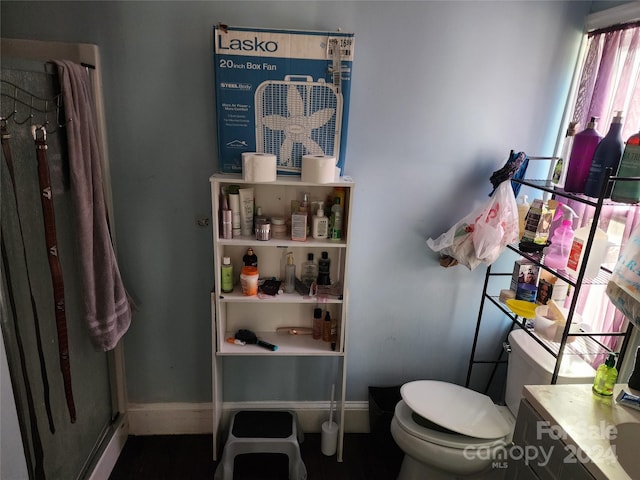 bathroom featuring vanity, toilet, and an enclosed shower