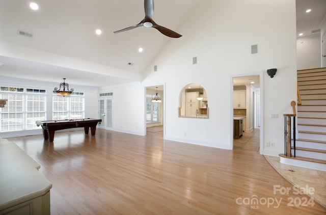 rec room with light hardwood / wood-style flooring, high vaulted ceiling, billiards, and ceiling fan with notable chandelier