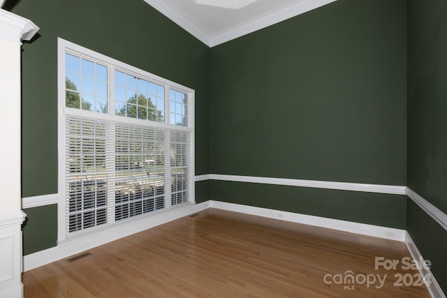 spare room featuring crown molding and wood-type flooring