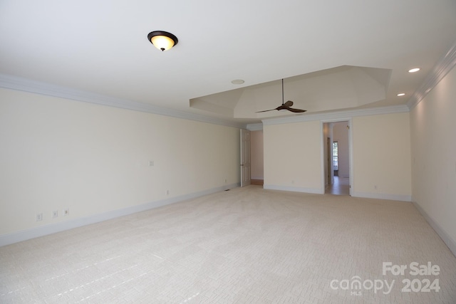 carpeted spare room featuring crown molding, a raised ceiling, and ceiling fan