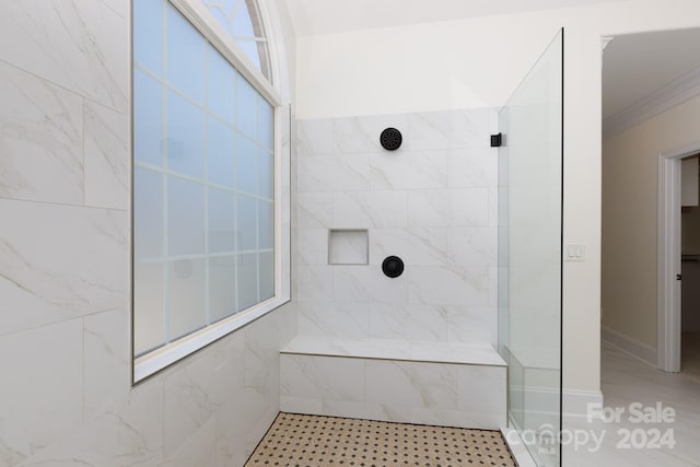 bathroom with a tile shower and ornamental molding