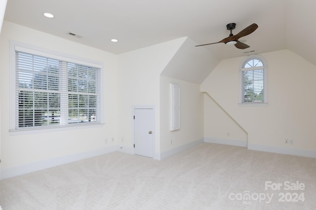 additional living space featuring ceiling fan, lofted ceiling, and light colored carpet