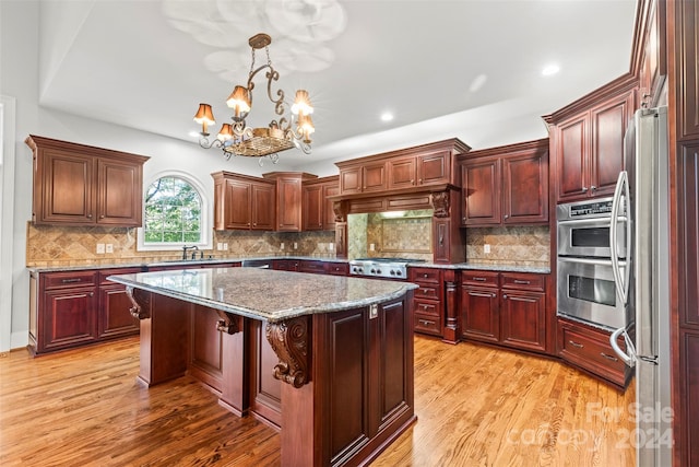 kitchen with light hardwood / wood-style flooring, sink, a center island, appliances with stainless steel finishes, and tasteful backsplash