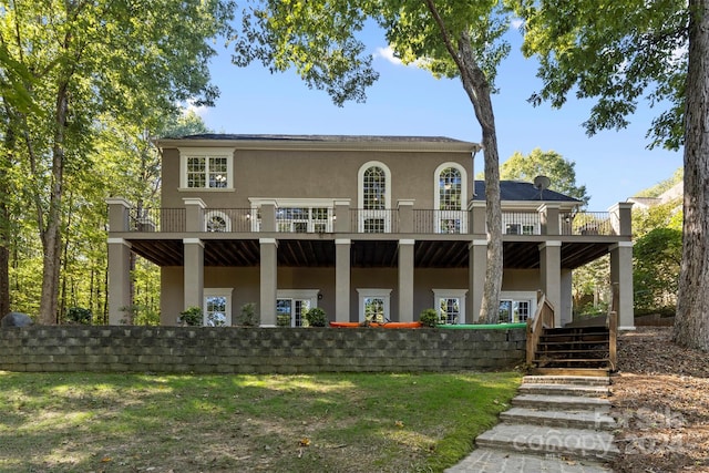 rear view of house with a deck and a lawn