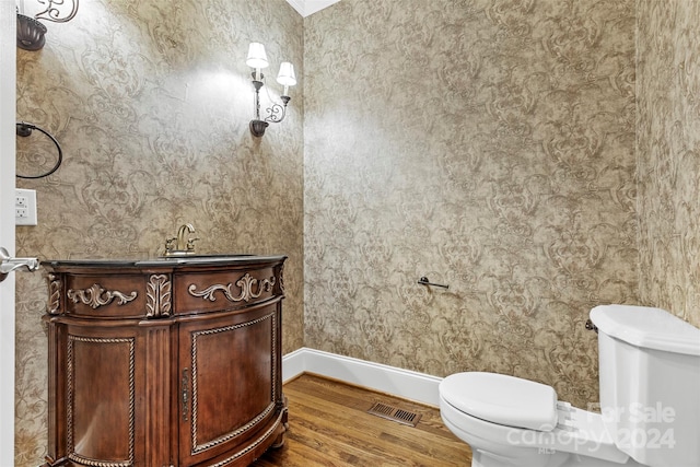 bathroom with vanity, toilet, and hardwood / wood-style floors