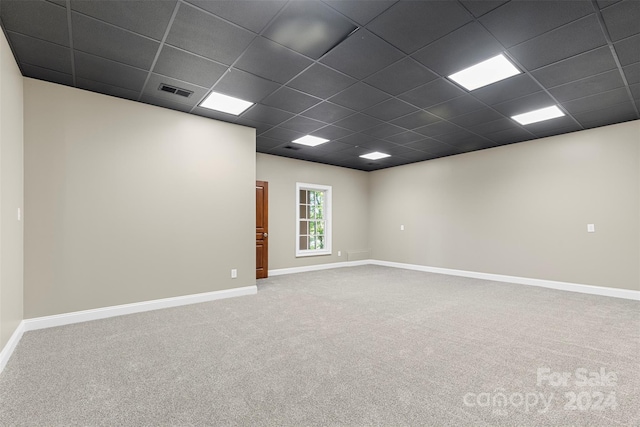 unfurnished room featuring a paneled ceiling and carpet