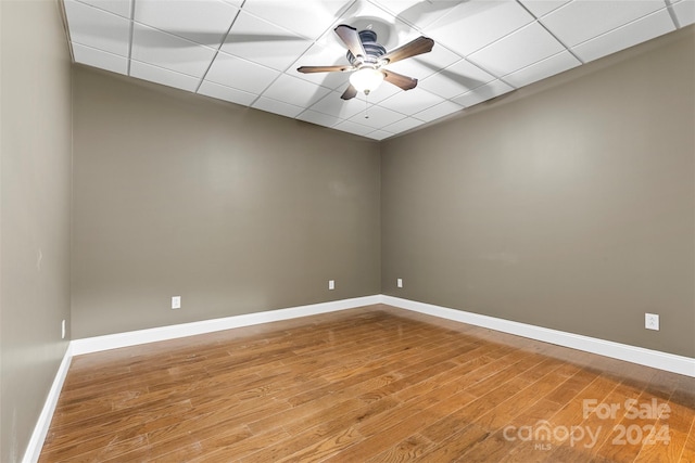 spare room with a drop ceiling, hardwood / wood-style flooring, and ceiling fan