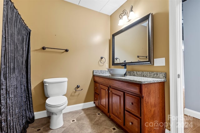 bathroom featuring vanity, toilet, and tile patterned flooring