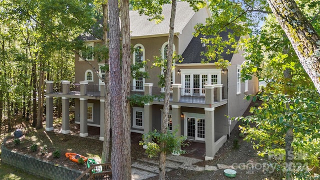 back of property with french doors and a balcony