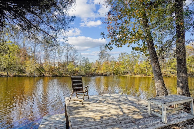 view of dock featuring a water view and a wooded view