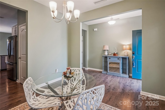 dining room with baseboards, wood finished floors, and a notable chandelier