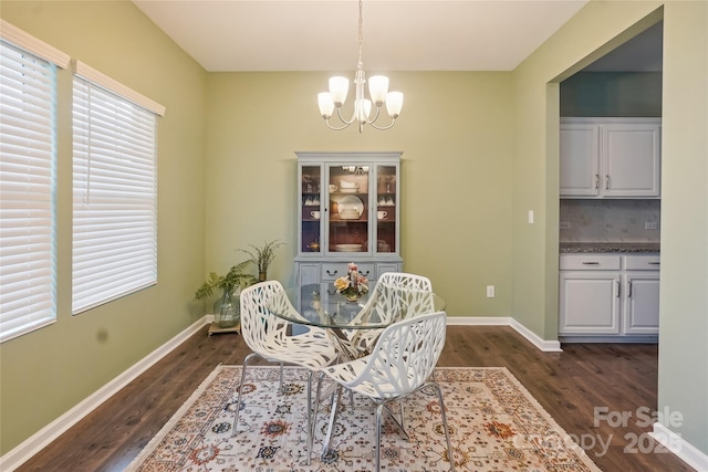 dining area with dark wood-style floors, baseboards, and a notable chandelier