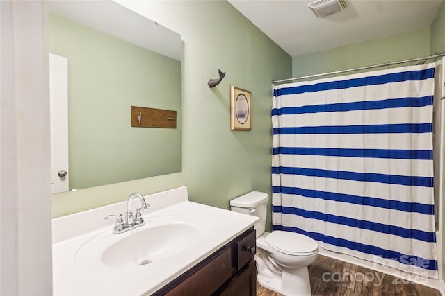 bathroom with visible vents, toilet, wood finished floors, curtained shower, and vanity