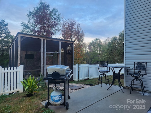 view of patio featuring a sunroom, fence, and grilling area