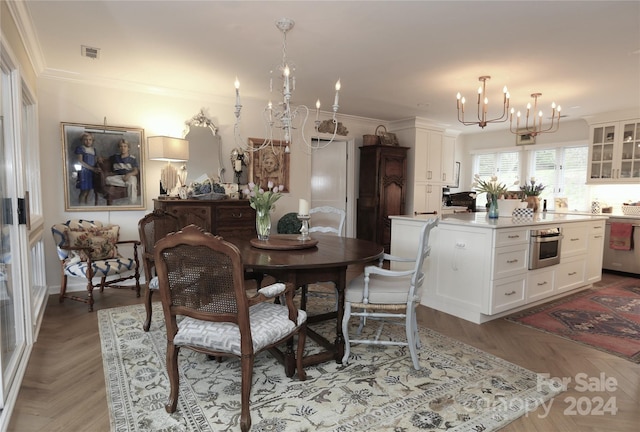 dining room featuring ornamental molding, light parquet floors, and an inviting chandelier