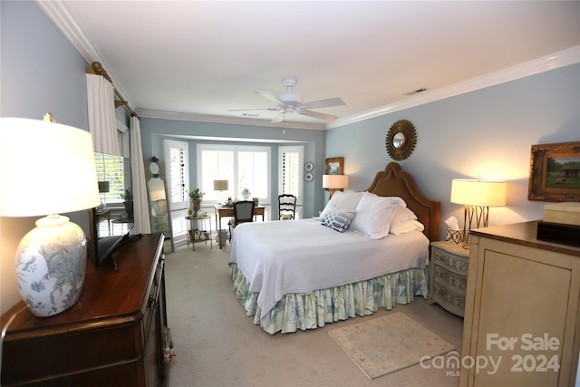 carpeted bedroom featuring ceiling fan and crown molding