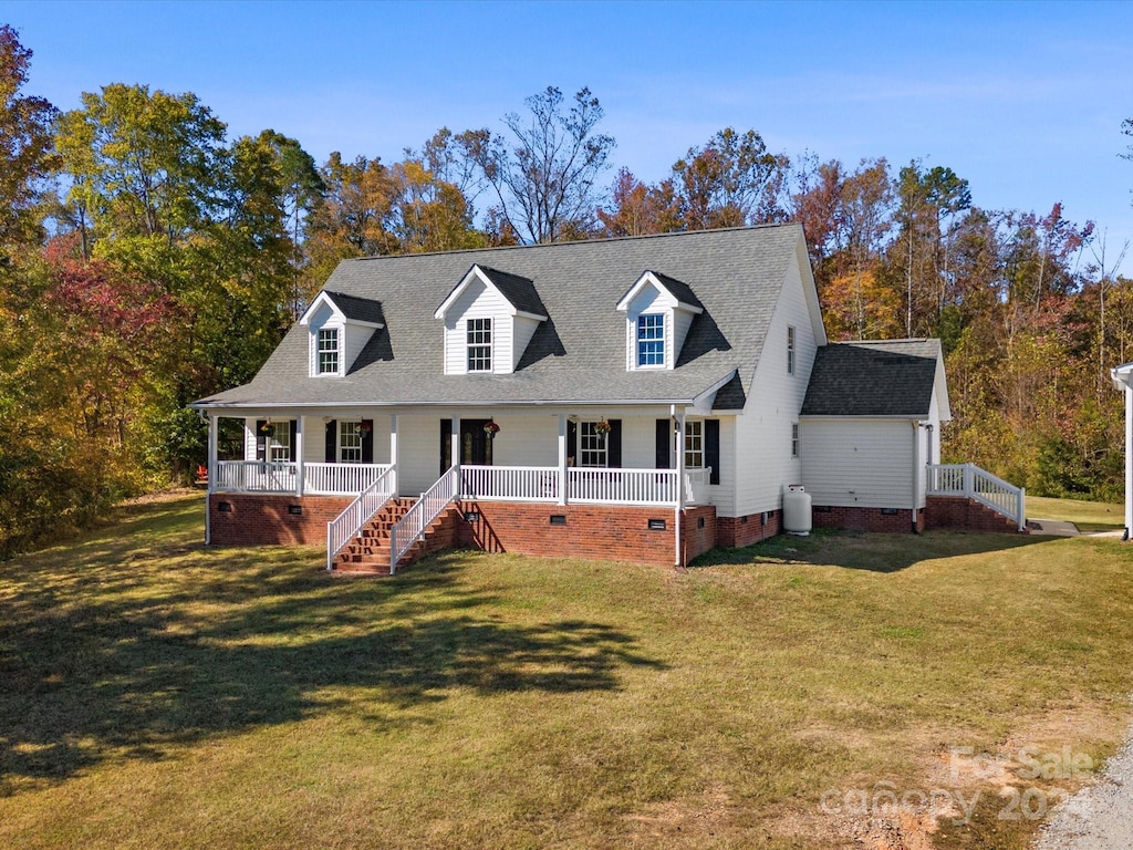 cape cod home featuring covered porch and a front lawn