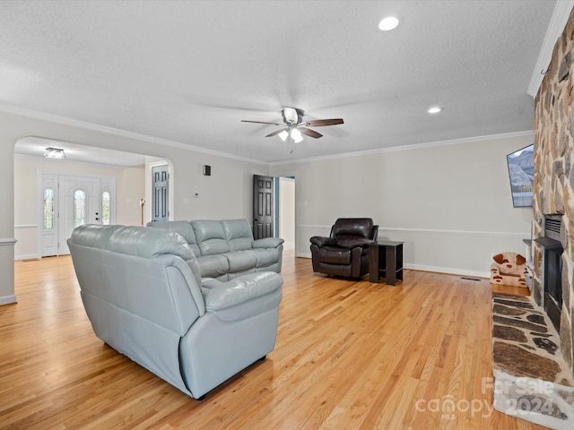 living room with light hardwood / wood-style flooring, a textured ceiling, ceiling fan, and crown molding