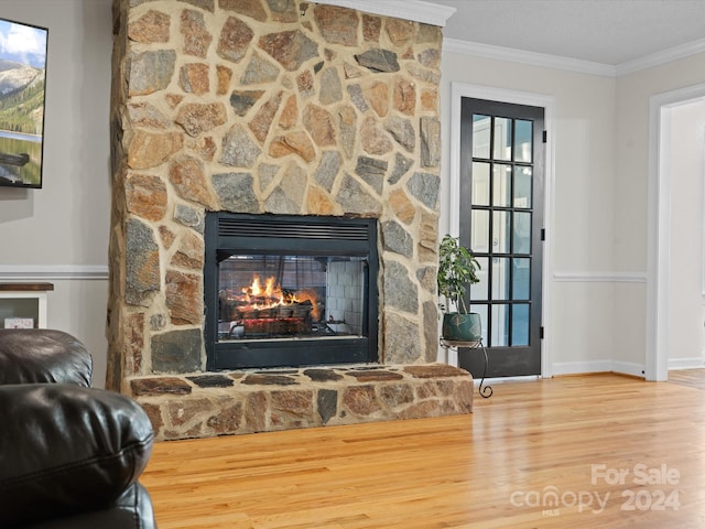 interior details with ornamental molding, hardwood / wood-style flooring, and a fireplace