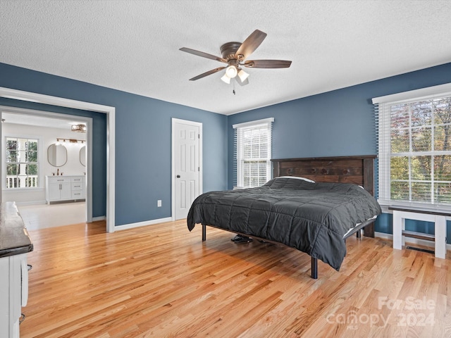 bedroom featuring a textured ceiling, multiple windows, light hardwood / wood-style floors, and ceiling fan