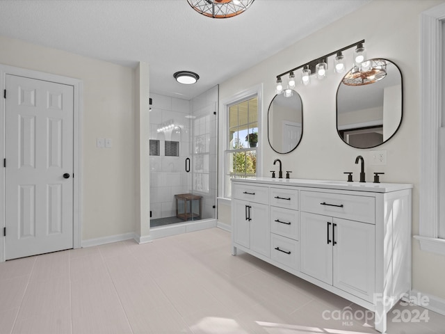 bathroom featuring vanity, an enclosed shower, a textured ceiling, and tile patterned floors